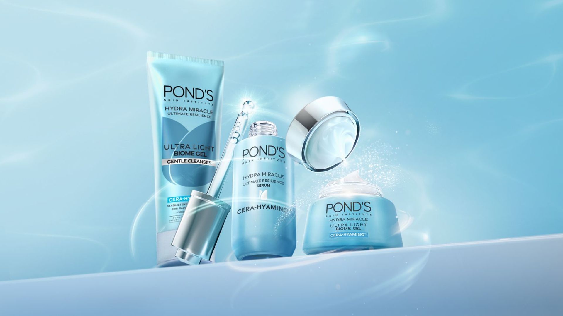 ผลิตภัณฑ์ Hydra Miracle Ultra Light จาก Pond’s จำนวน 3 ชิ้น สีน้ำเงินที่ประดับด้วยสีเงิน ขวดเซรั่มเปิดอยู่ และมองเห็นหลอดหยดได้อย่างชัดเจน