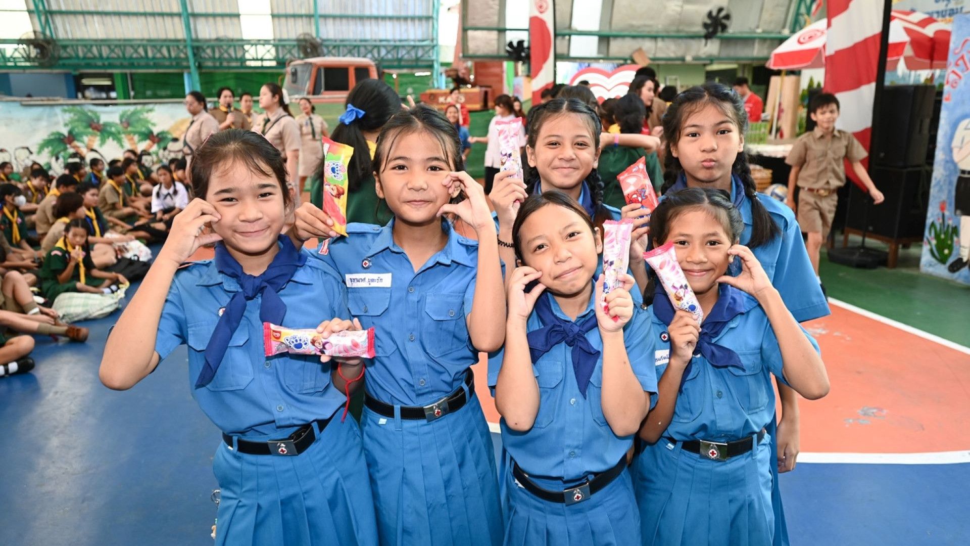 ภาพแสดงกลุ่มเด็กนักเรียนหญิงถือไอสครีมวอลล์พร้อมรอยยิ้ม