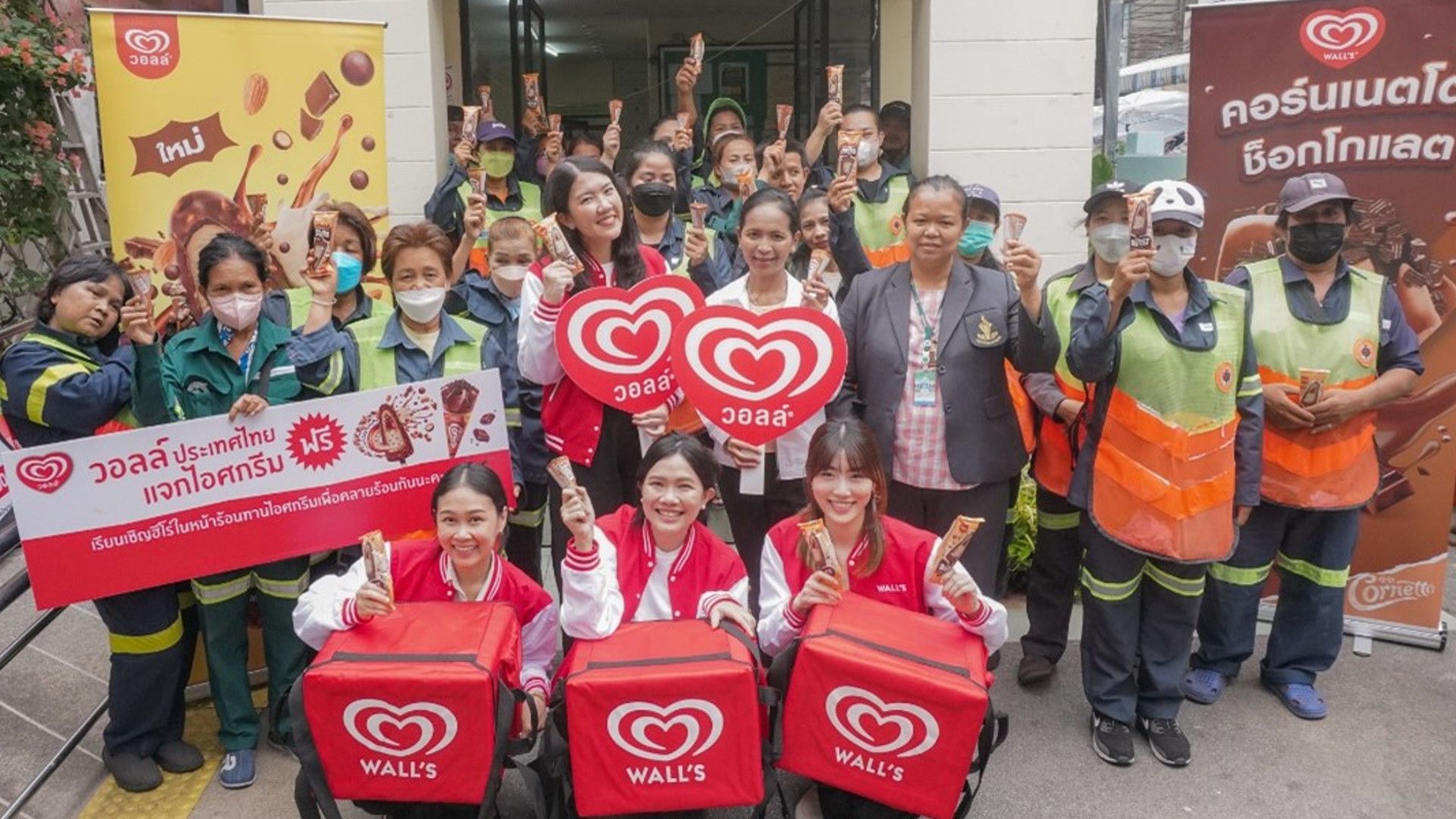  คนกลุ่มหนึ่งถือไอศกรีม แบนเนอร์ และโลโก้ของ Wall.